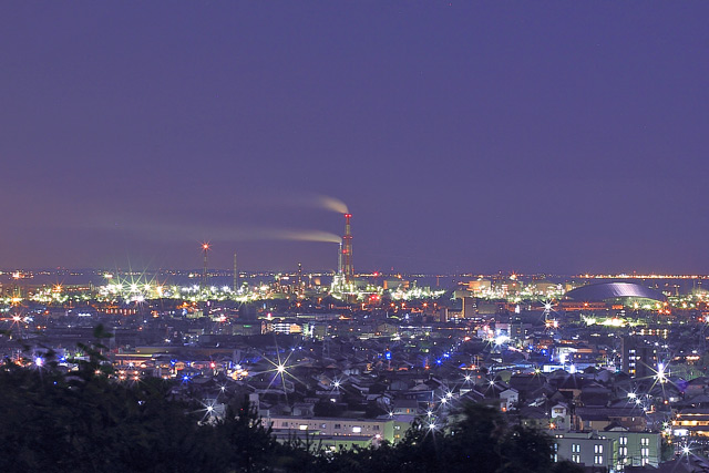 煙突から煙が噴き出す工場夜景