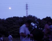 望遠鏡で満月を観賞する少年